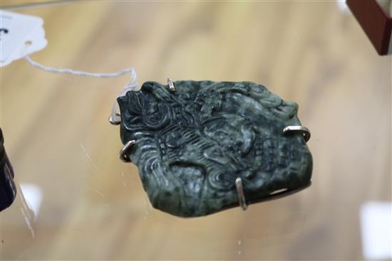 A Mayan jadeite carving of a mask in a white metal mount